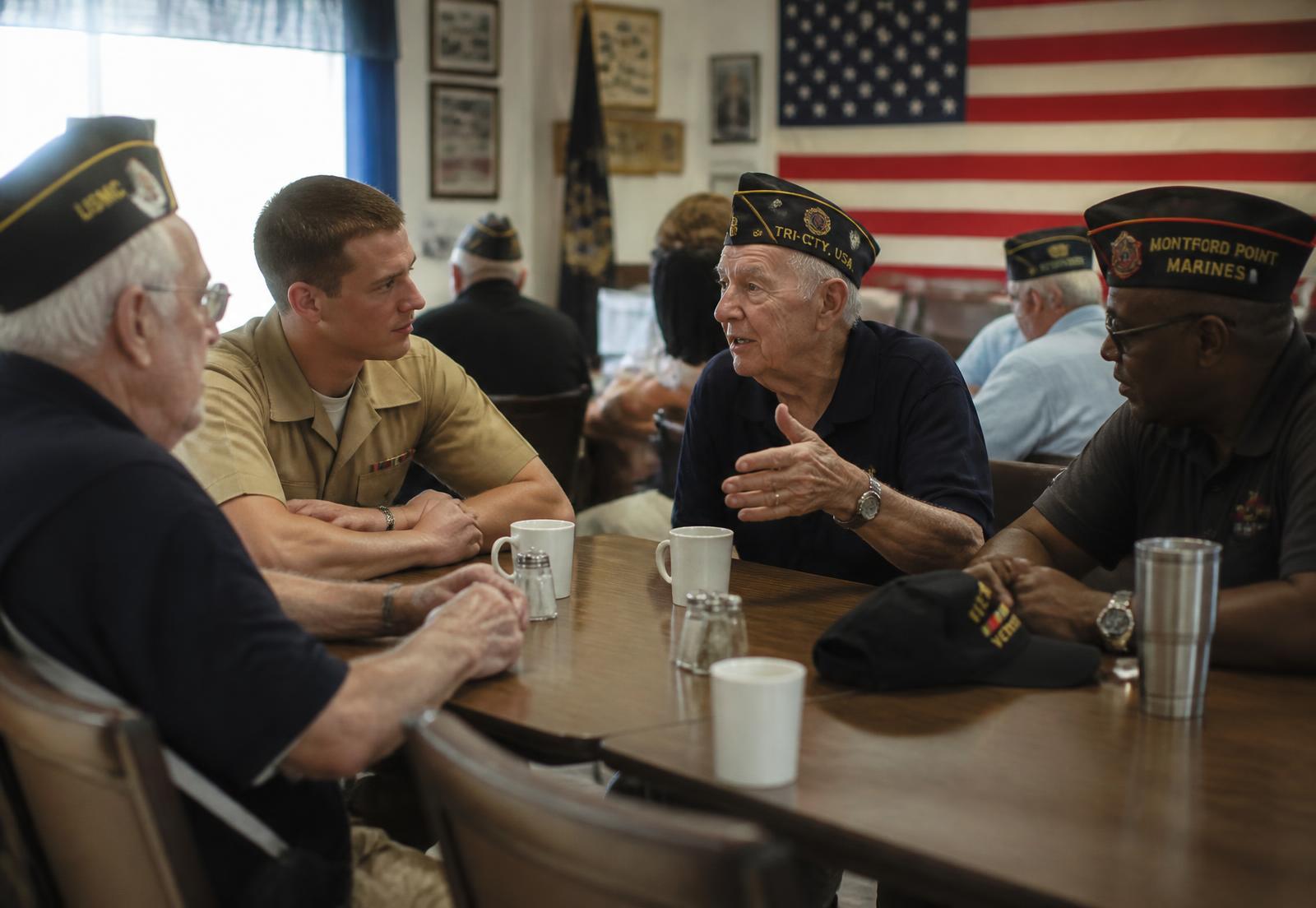 Veterans of several generations talking over coffee inside the Post 9 hall